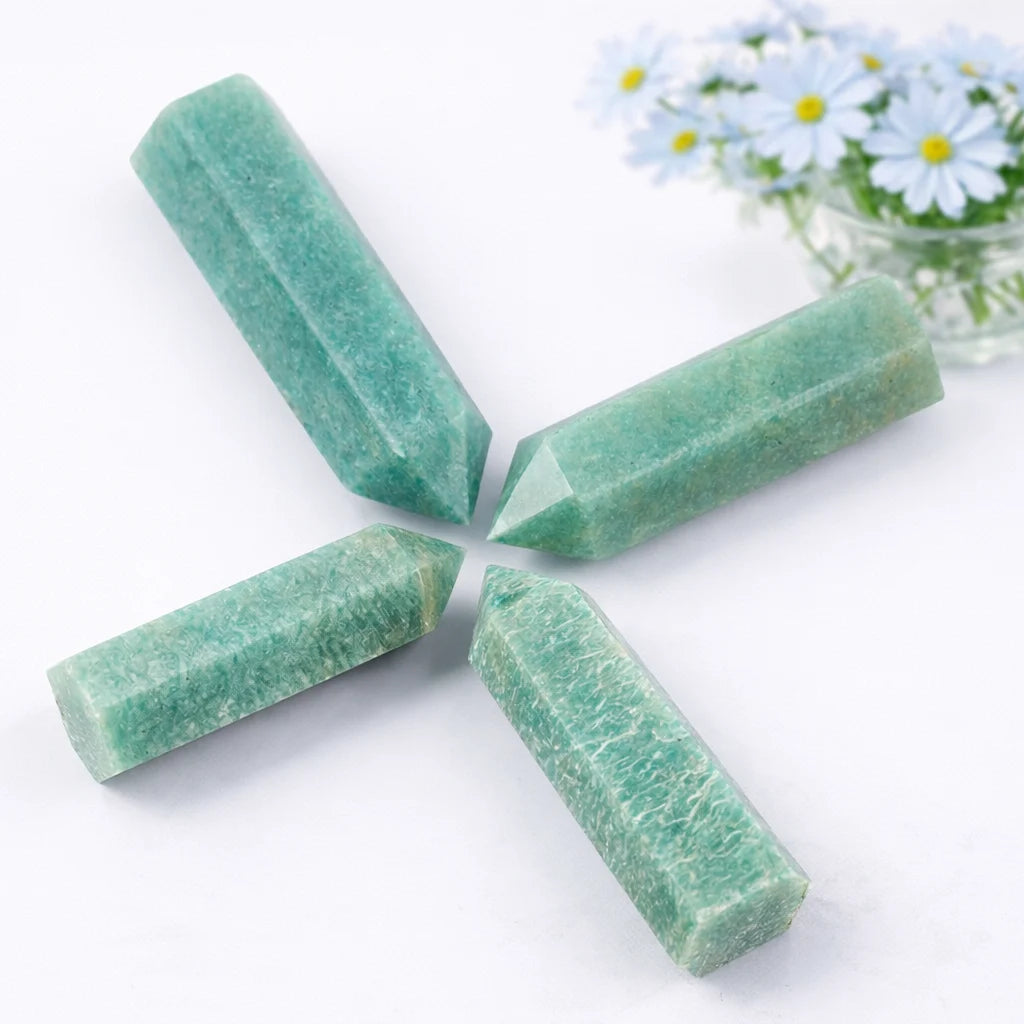 Amazonite healing crystal tower standing upright with smooth finish, white backdrop, soft shadow, and light blue daisy decor