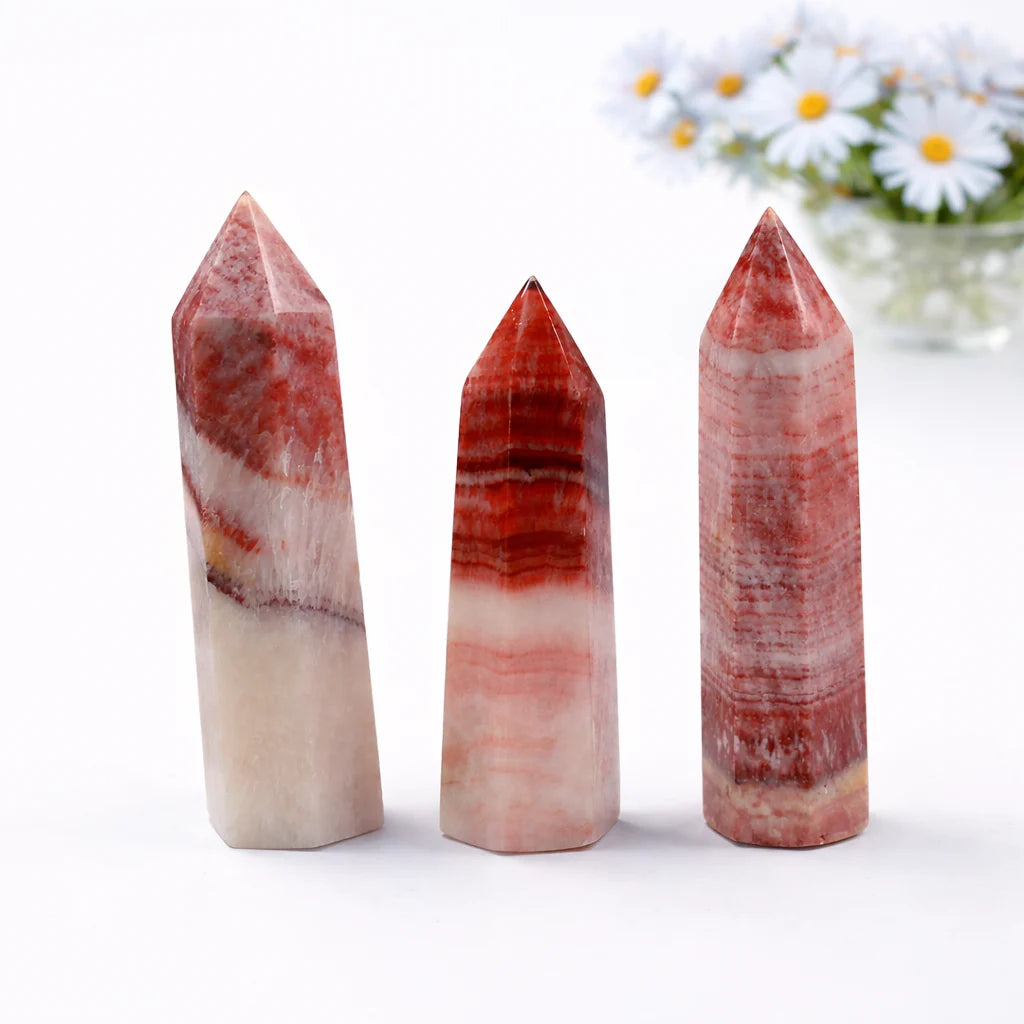 Natural Dali jasper crystal point with red and beige patterns, minimal white background and soft lighting